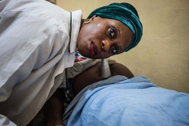 A midwife examines a pregnant woman.